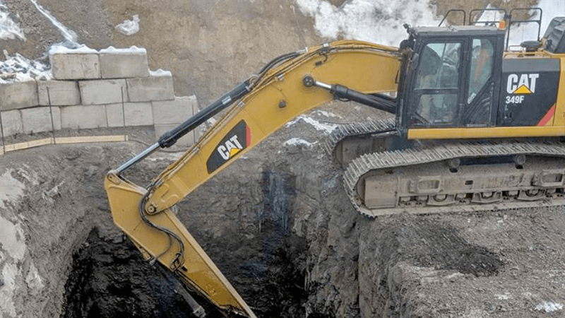 Excavator Digging Into Rocky Ground At A Construction Site Png