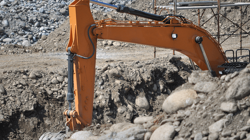 Excavator Digging Into Rocky Soil At A Construction Site Png