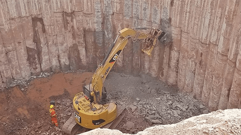 An Excavator Equipped With A Rockwheel Trimming A Secant Pile Wall Jpg