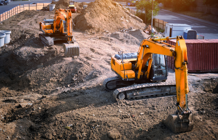Two excavators digging and moving soil at an active construction site