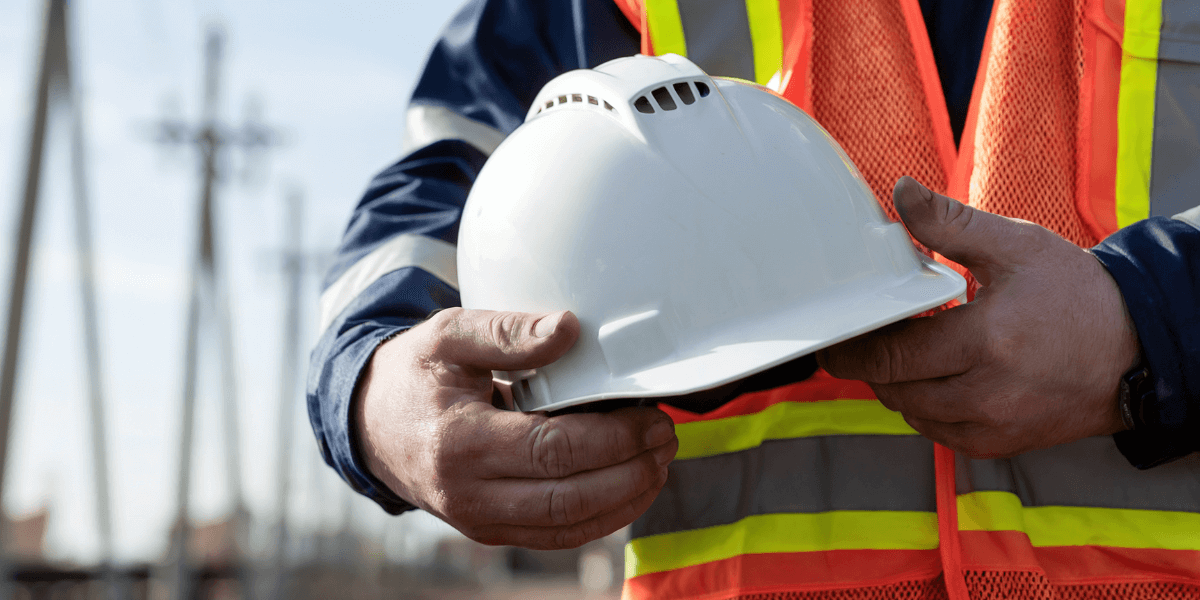 Construction worker holding a safety helmet at a job site